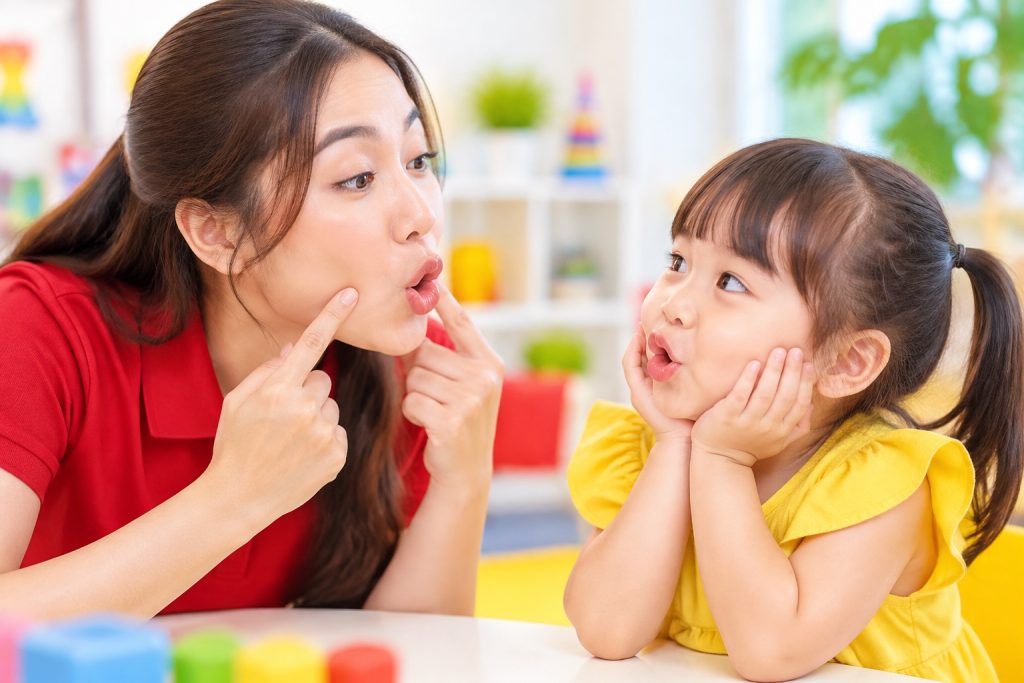 Cô giáo cho trẻ nhìn khẩu hình miệng khi phát âm